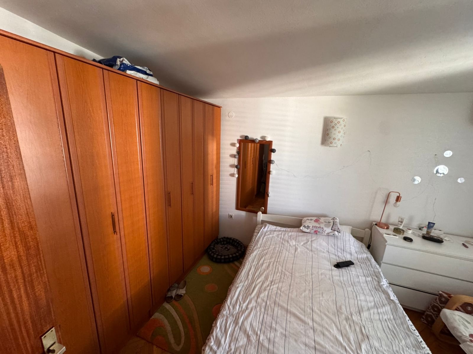 Bright Ulcinj bedroom with wooden wardrobe, single bed, dresser, and mirror&mdash;ideal investment on immorenta.me by ekosphere doo.