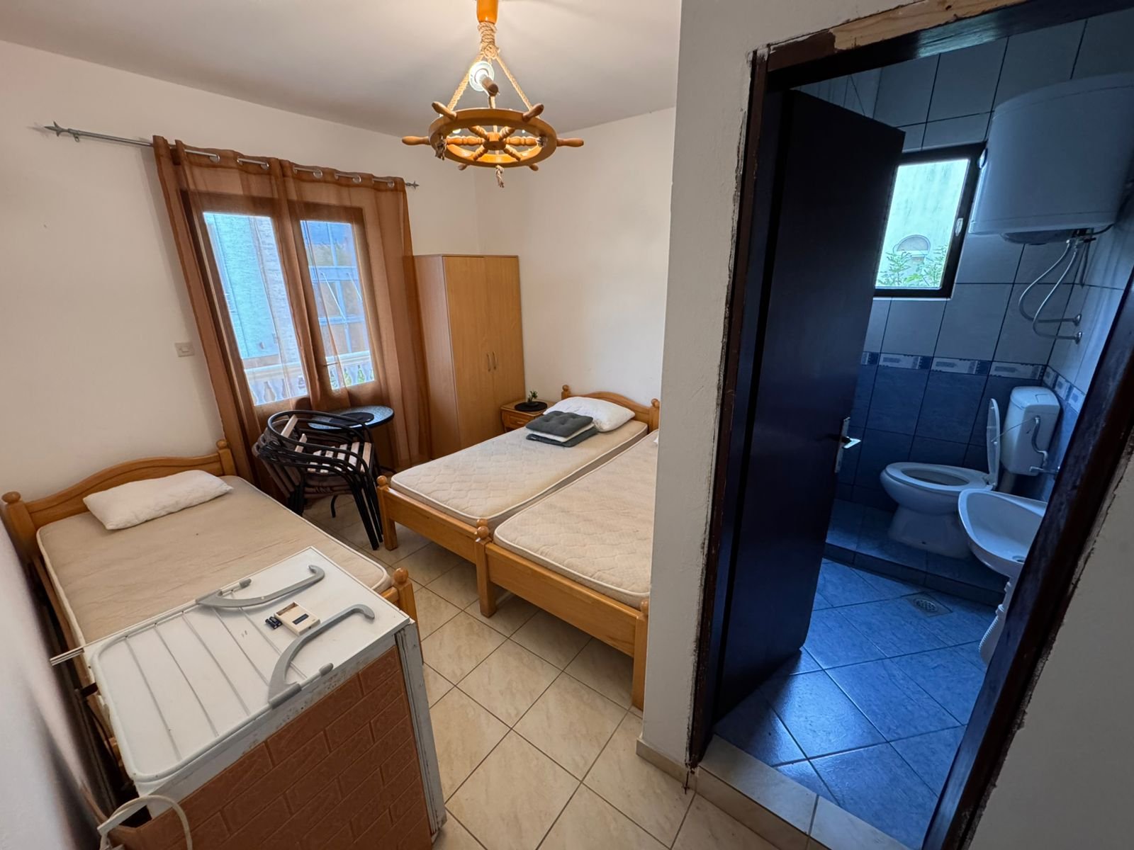 Bright hotel room in Ulcinj with 2 single beds, extra bed, wood furniture, private bath; prime investment via immorenta.me.