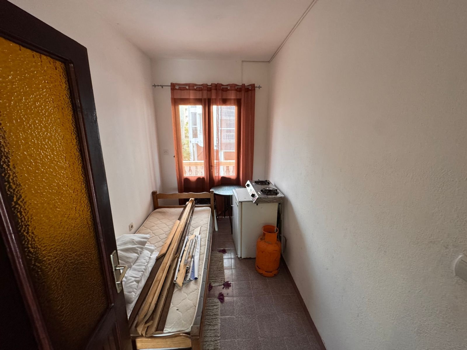 Bright, compact room in Ulcinj with bed, stove, and window&mdash;ideal Montenegro investment. Listed on immorenta.me by ekosphere doo.