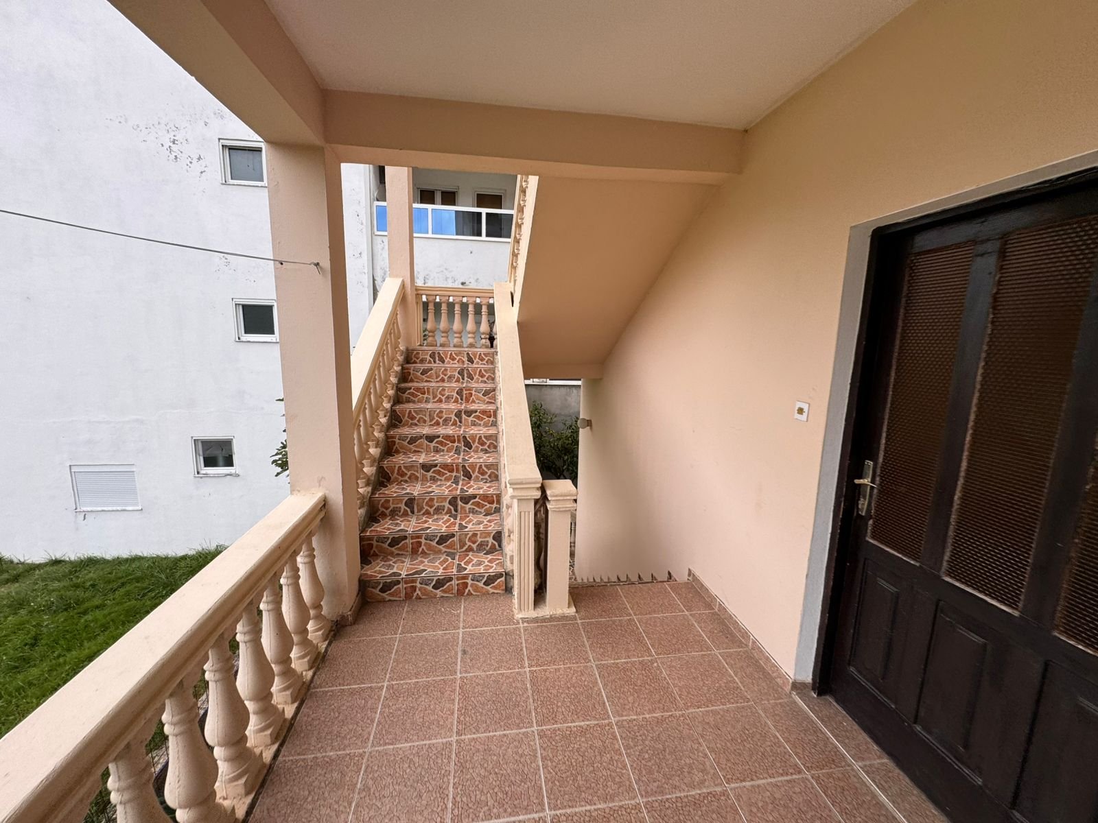 Stylish Ulcinj property: elegant tiled entry, premium wood door, designer staircase, garden views. Invest at immorenta.me by ekosphere doo.