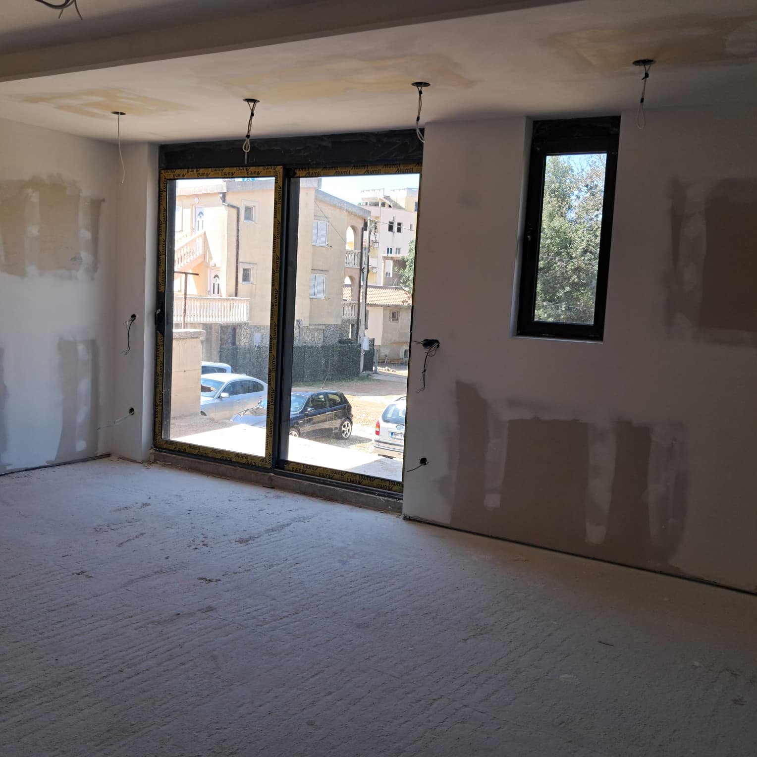 Spacious unfinished room in Ulcinj, Montenegro, ideal for investment. Large windows with street views. Exclusive at immorenta.me, a project of ekosphere doo.