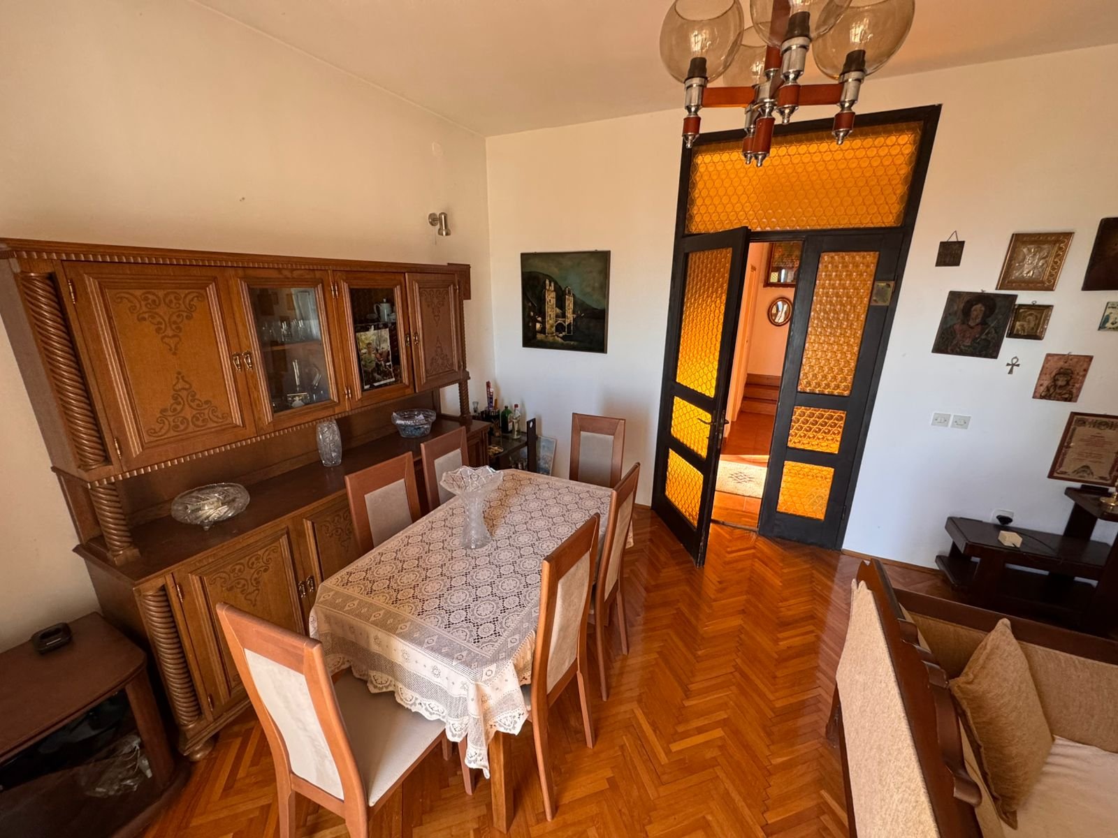 Spacious Ulcinj dining room: wooden table, elegant lace, 6 chairs, glass doors, ambient d&eacute;cor. Invest with immorenta.me.