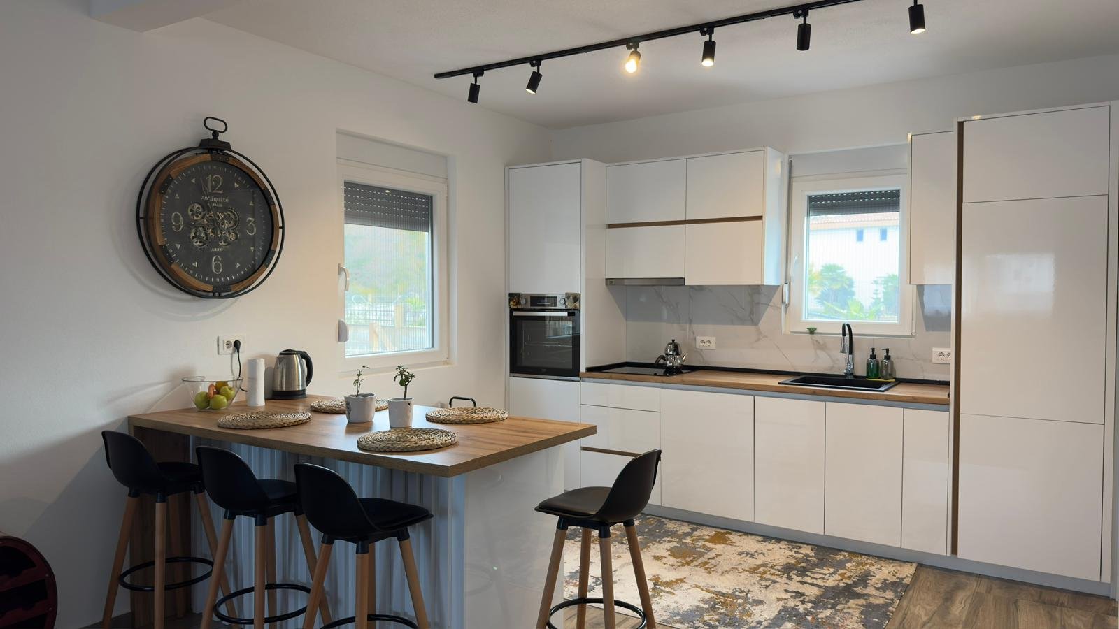 Elegant Ulcinj kitchen: bright, modern design with white cabinets, island bar, wood tops, premium oven. Exclusive at immorenta.me by ekosphere doo.