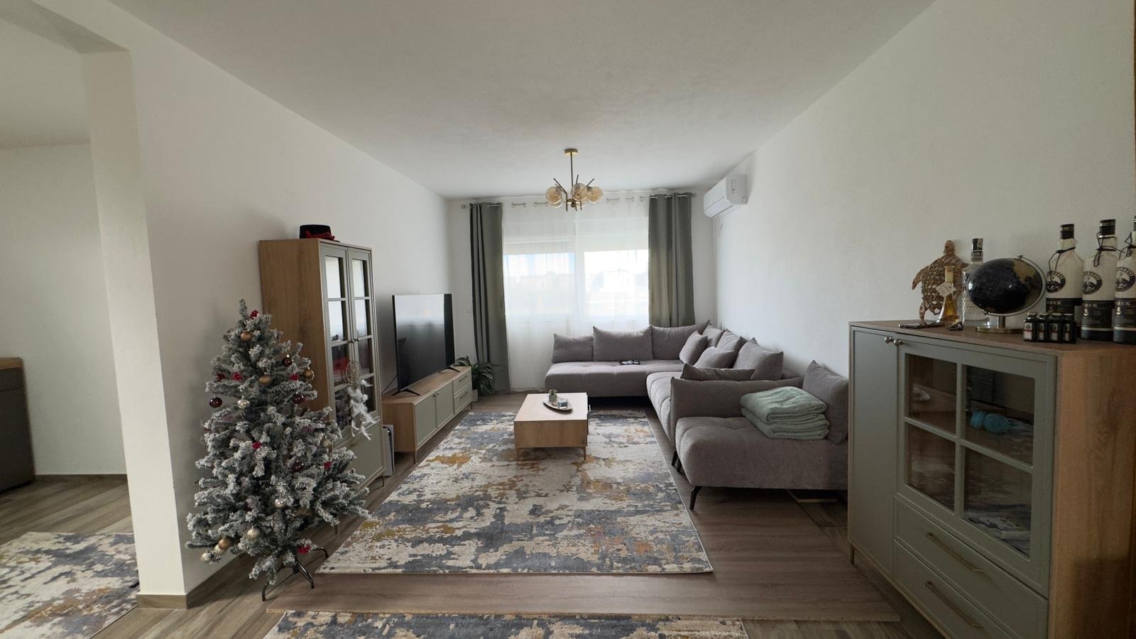 Stunning Ulcinj apartment: modern living room, gray sectional sofa, large windows, stylish decor. Exclusive at immorenta.me by ekosphere doo.