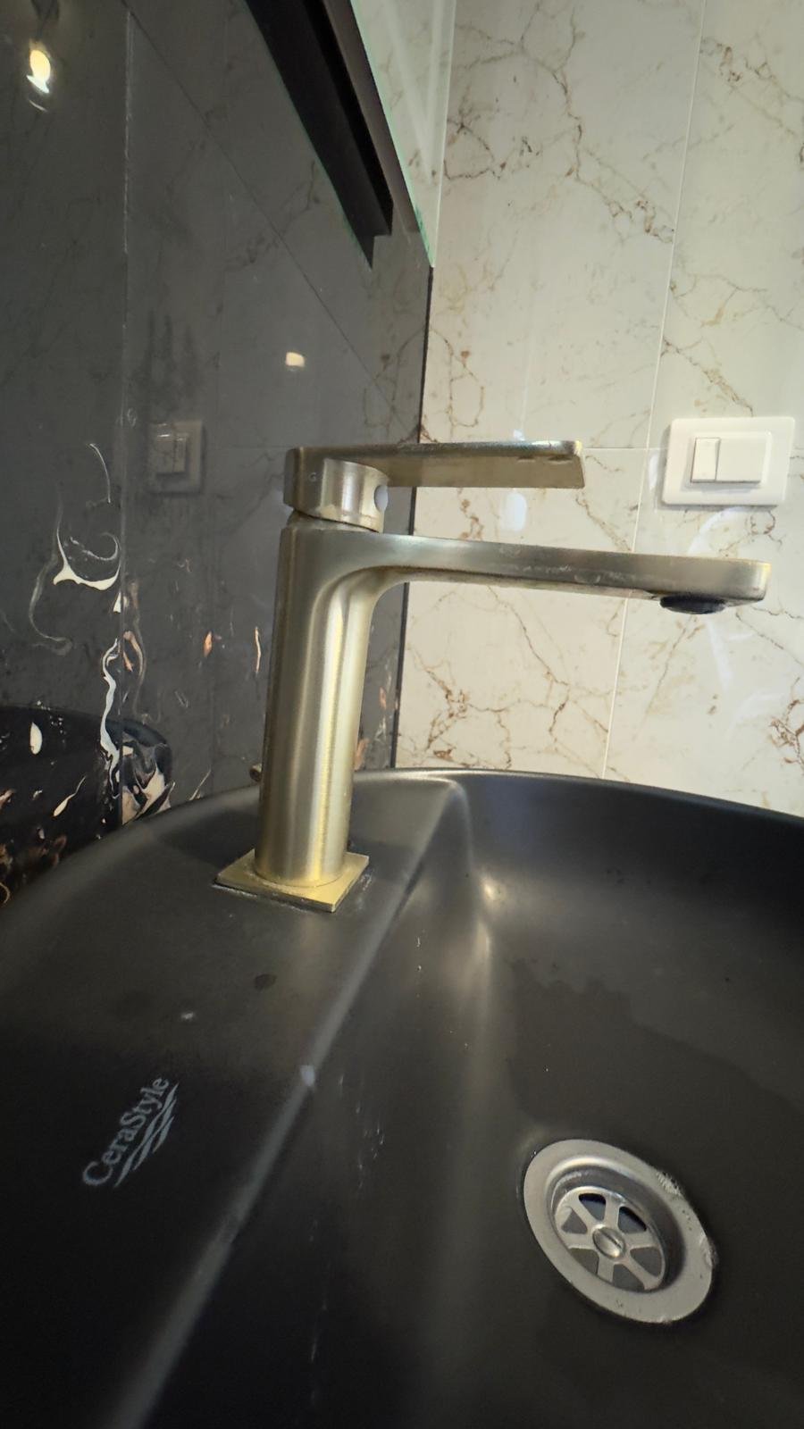 Luxury Ulcinj property: Gold faucet on a Cersanit black sink, marble tiles. Exclusive listing by immorenta.me (ekosphere doo).