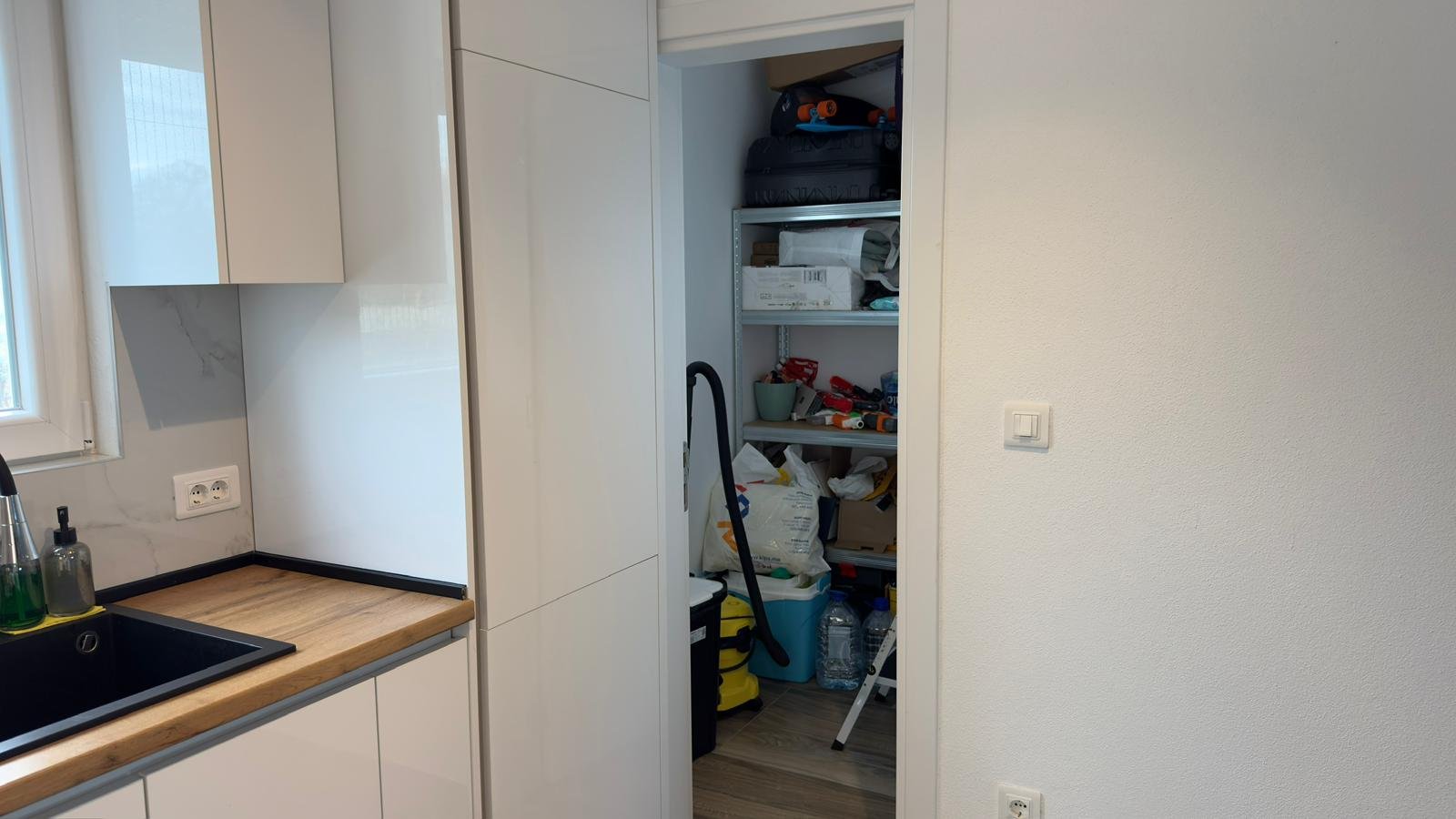 Modern Ulcinj kitchen with white cabinets, wooden countertops, and organized storage; exclusive at immorenta.me by ekosphere doo.