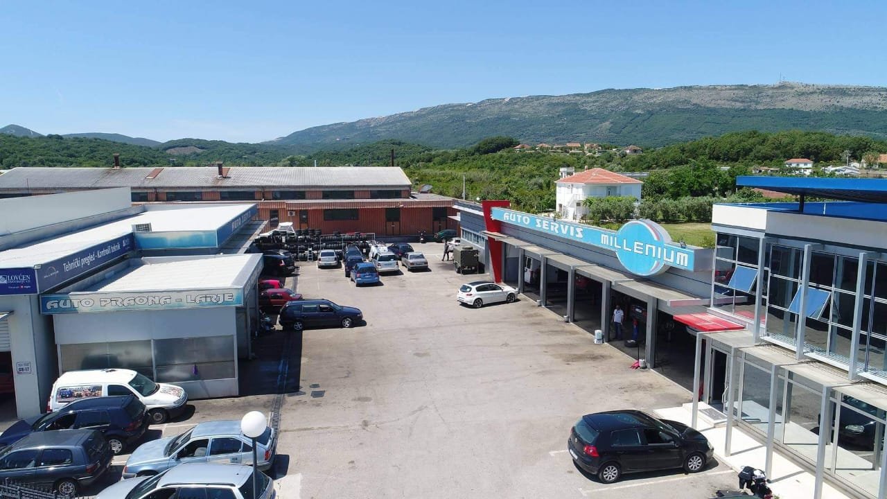 Prime commercial property in Ulcinj, Montenegro: spacious paved lot with auto shops, scenic hills&mdash;ideal investment at immorenta.me.
