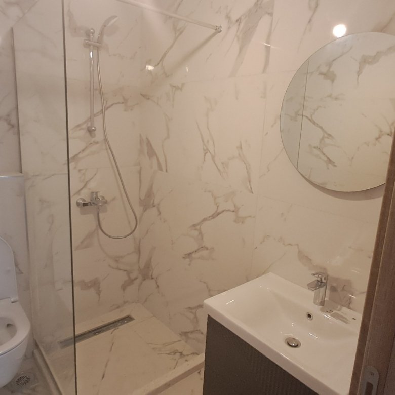 Modern bathroom in Ulcinj with marble-patterned walls, walk-in shower, and premium finishes&mdash;exclusive Montenegro-listings.me by ekosphere doo.