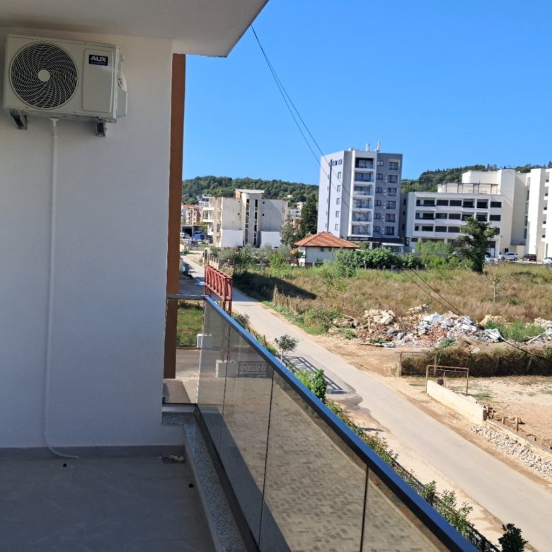 Modern balcony view with glass railing, air conditioning, and cityscape&mdash;prime Ulcinj investment on immorenta.me by ekosphere doo.