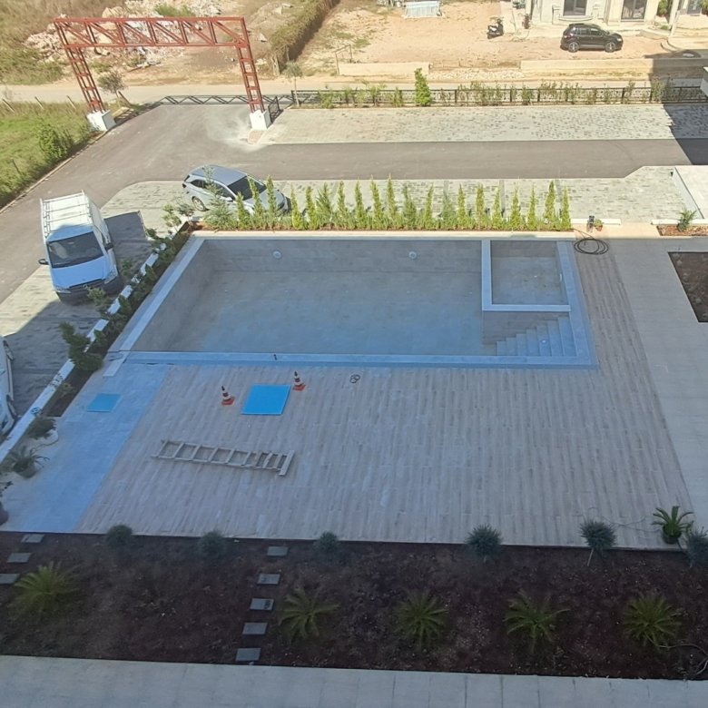 Spacious paved courtyard with rectangular pool, decorative greenery; excellent Ulcinj real estate from immorenta.me by ekosphere doo.