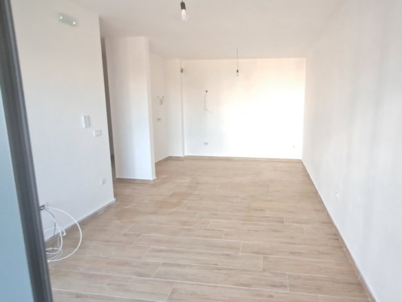 Ger&auml;umiges, helles Zimmer mit hochwertigem hellem Holzfu&szlig;boden und frischen wei&szlig;en W&auml;nden - ideal f&uuml;r eine Immobilieninvestition in Ulcinj, Montenegro. Powered by ekosphere doo via immorenta.me. 