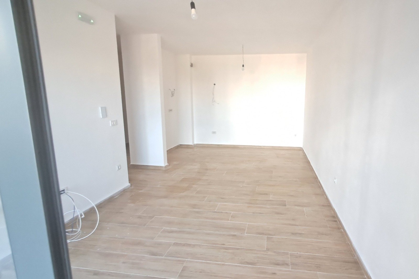 Spacious, bright room with premium light wood flooring and fresh white walls&mdash;ideal for property investment in Ulcinj, Montenegro. Powered by ekosphere doo via immorenta.me.