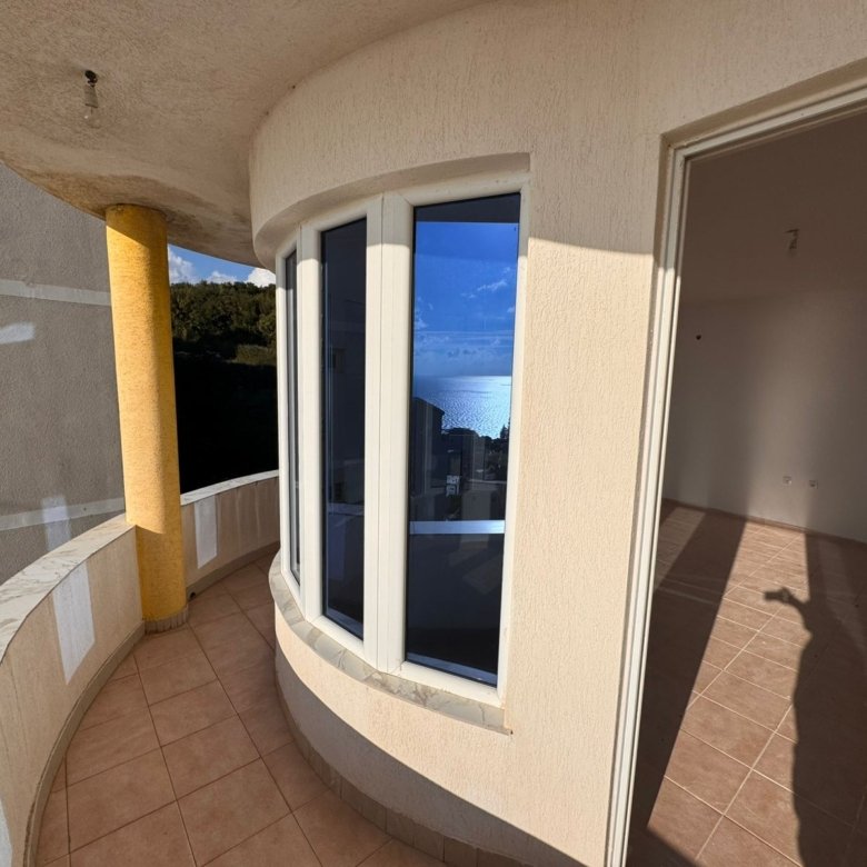 Spacious curved balcony with sea view, tiled floors, bay windows. Prime Ulcinj property via immorenta.me by ekosphere doo.