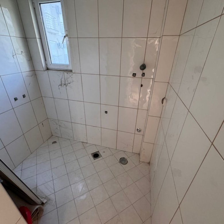 Bright, tiled bathroom in Ulcinj with window and plumbing&mdash;ideal for customizing. Great investment via immorenta.me by ekosphere doo.