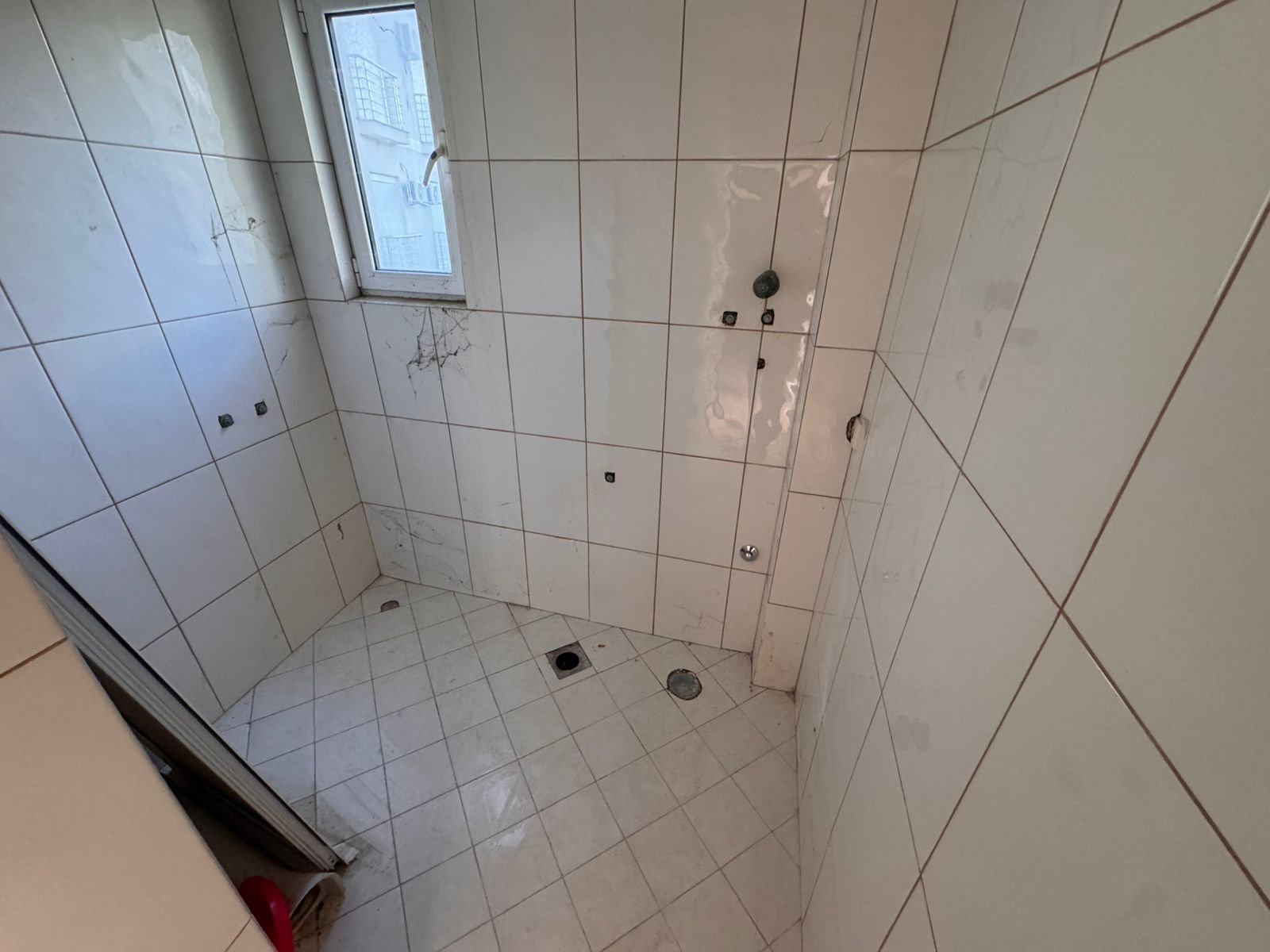 Bright, tiled bathroom in Ulcinj with window and plumbing&mdash;ideal for customizing. Great investment via immorenta.me by ekosphere doo.