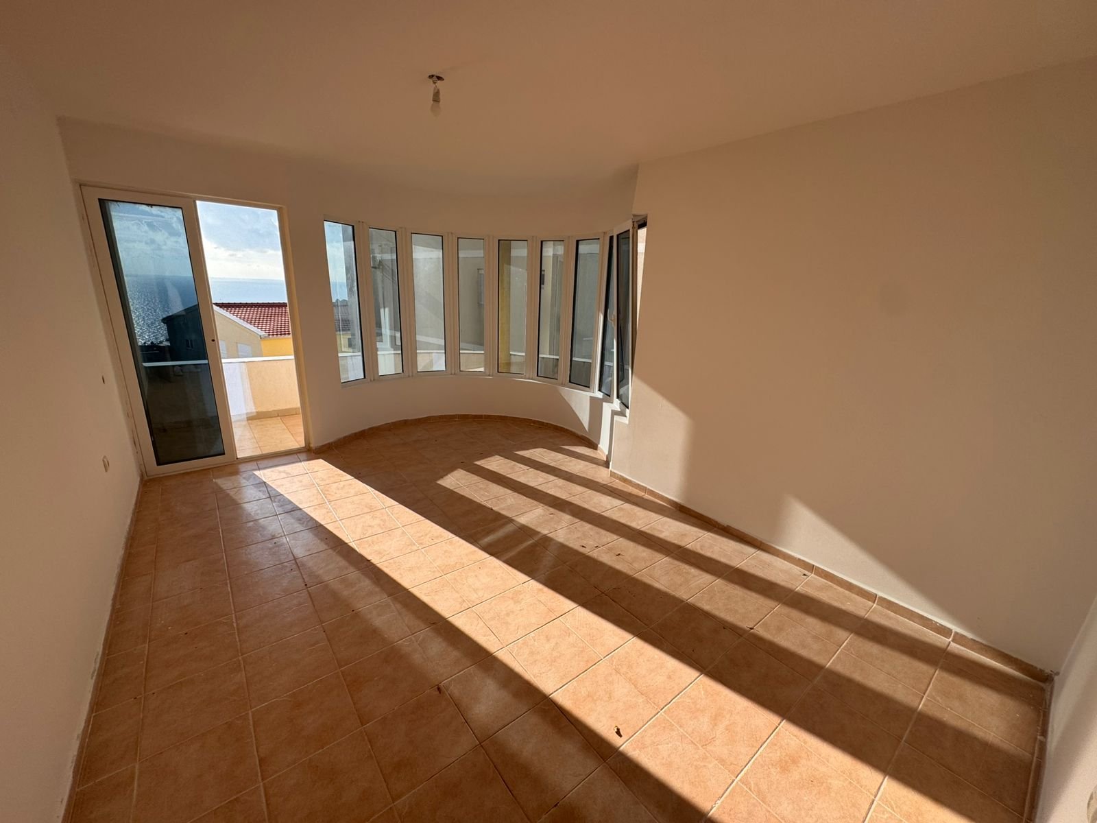 Experience bright, modern living in Ulcinj: spacious sunlit room with panoramic windows, balcony access, exclusive on immorenta.me by ekosphere doo.