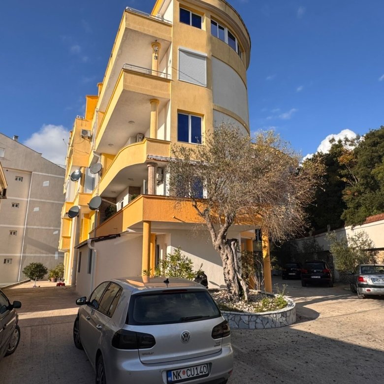 Modern three-story apartment building in Ulcinj, Montenegro&mdash;ideal investment with balconies, parking, and lush trees. eksosphere doo.