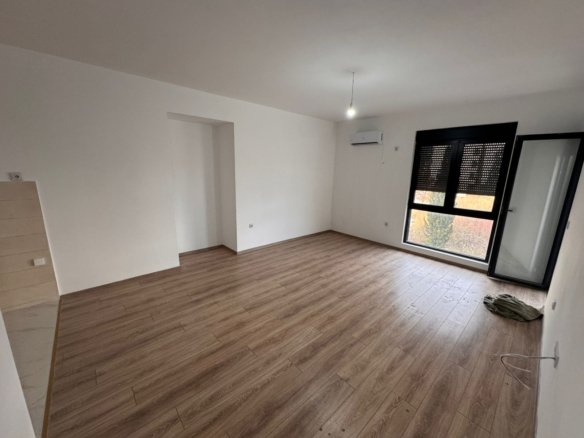 Bright unfurnished room in Ulcinj with wood floors, AC, large window, balcony door. Ideal Montenegro investment at immorenta.me.