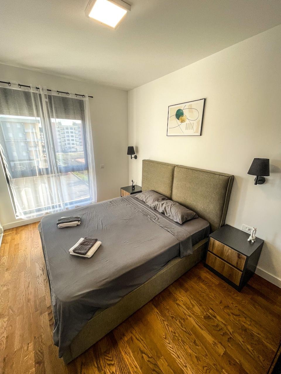 Stylish modern bedroom in Ulcinj with a double bed, wood floors, elegant lighting&mdash;premium property on immorenta.me by ekosphere doo.