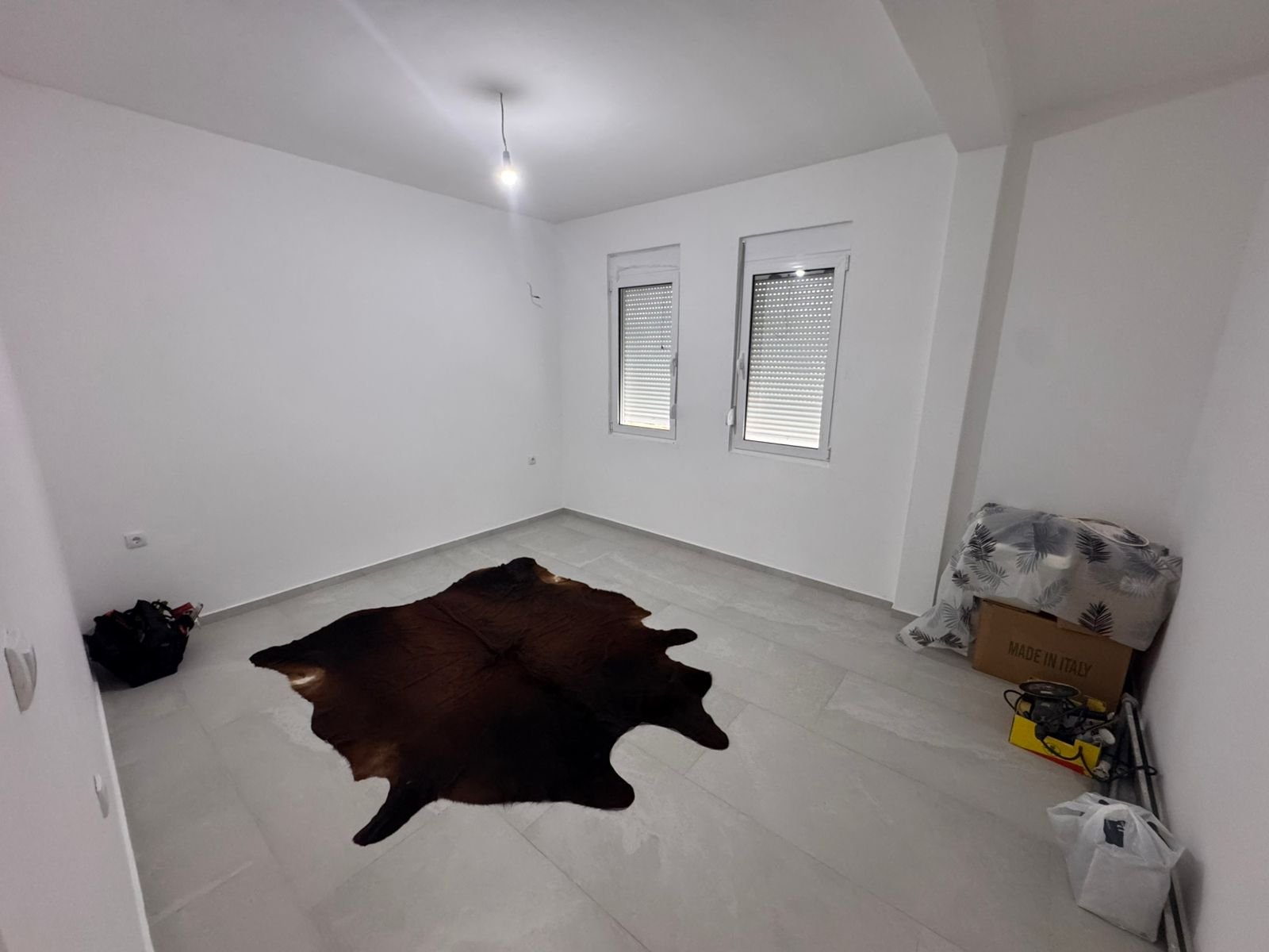 Bright white room in Ulcinj, Montenegro&mdash;ideal for investment&mdash;features windows, designer rug, storage space. eksosphere doo project.