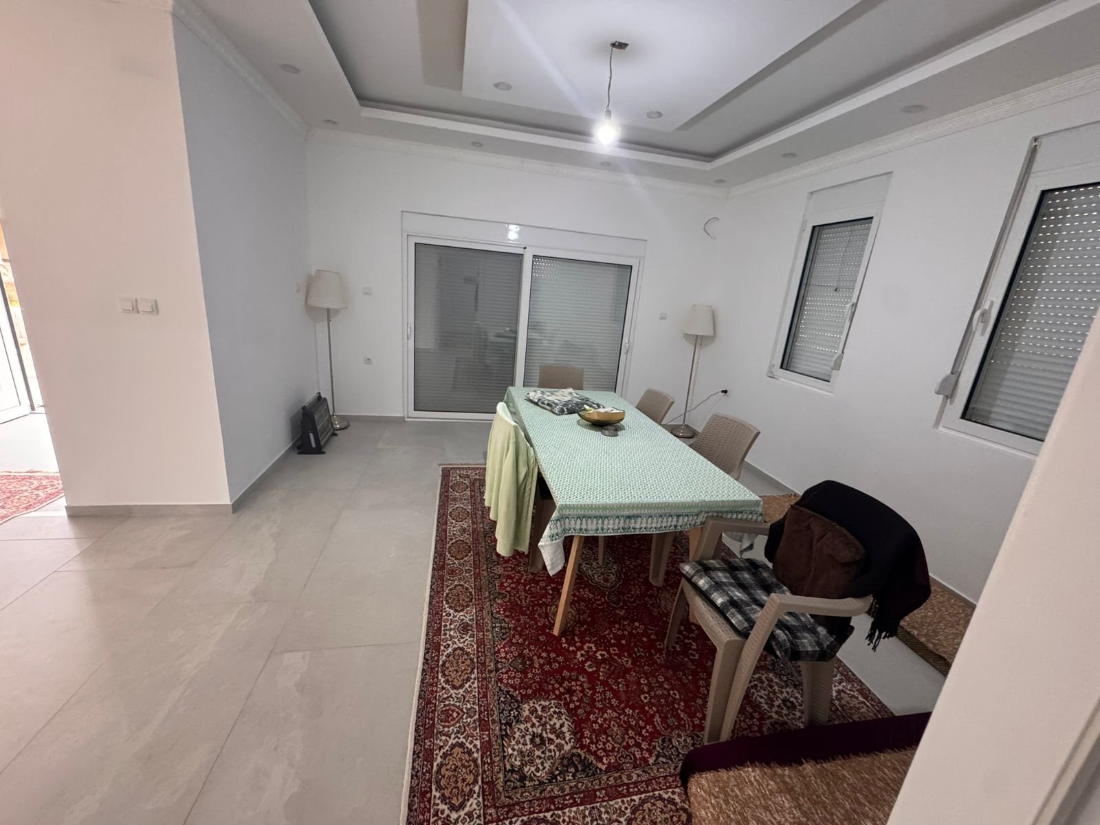 Bright dining space in Ulcinj with tiled floors, modern lighting, and large windows&mdash;exclusive at immorenta.me by ekosphere doo.