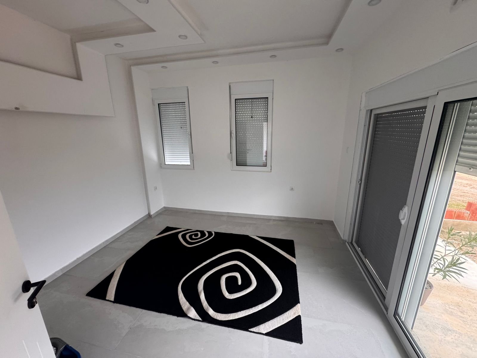 Modern Ulcinj apartment: bright room, white walls, stylish tile floors, quality finishes. Exclusive on immorenta.me by ekosphere doo.