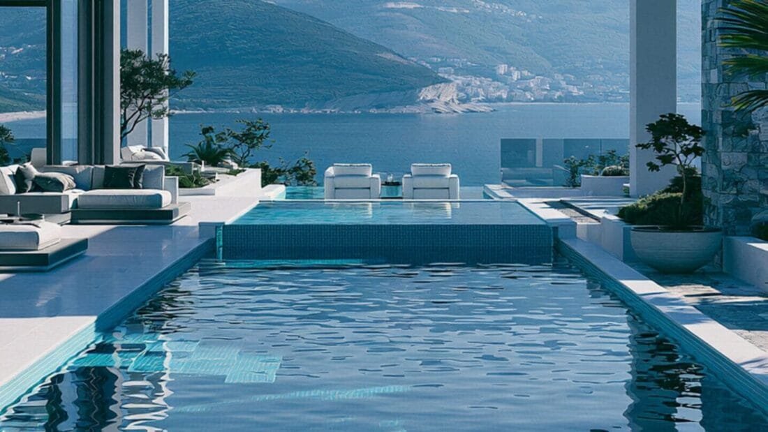 Rückzugsort Montenegro - Moderne Villa mit rechteckigem Pool, am Rand Liegestühle, im Hintergrund Meer und Berge unter klarem Himmel.