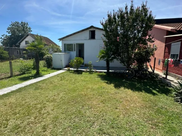 Charming white house with glass door on lush lawn, prime Ulcinj location near amenities&mdash;exclusive at immorenta.me by ekosphere doo.