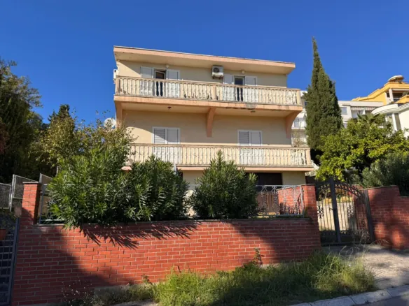 Premium three-story beige house in Ulcinj with 2 balconies, lush greenery, brick fence. Top Montenegro investment at immorenta.me by ekosphere doo.