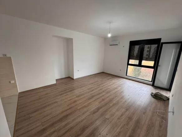 Bright unfurnished room in Ulcinj with wood floors, AC, large window, balcony door. Ideal Montenegro investment at immorenta.me.